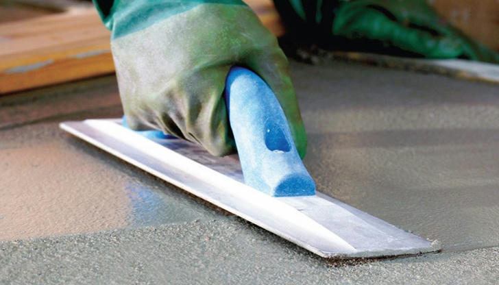 Which tool is commonly used to smooth the concrete surface during finishing?