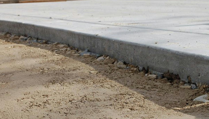 What is the typical thickness for a residential concrete driveway slab?