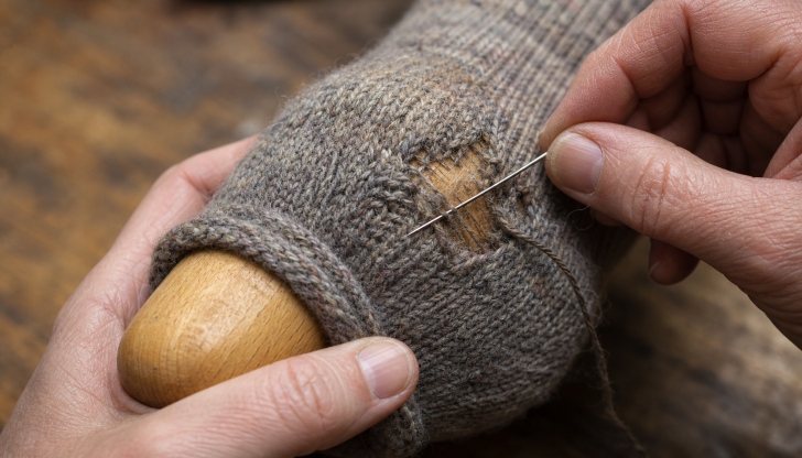 What wooden, egg-shaped object was slipped inside socks to help mend holes in the heel or toe?