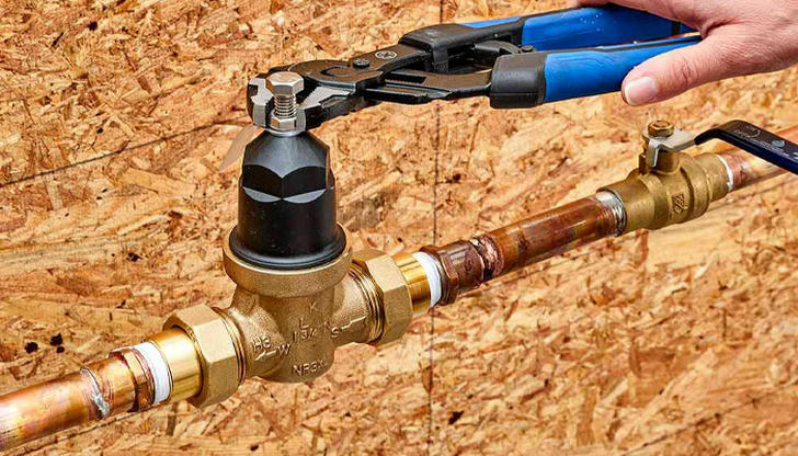 What is the safest way to release water pressure in a system?