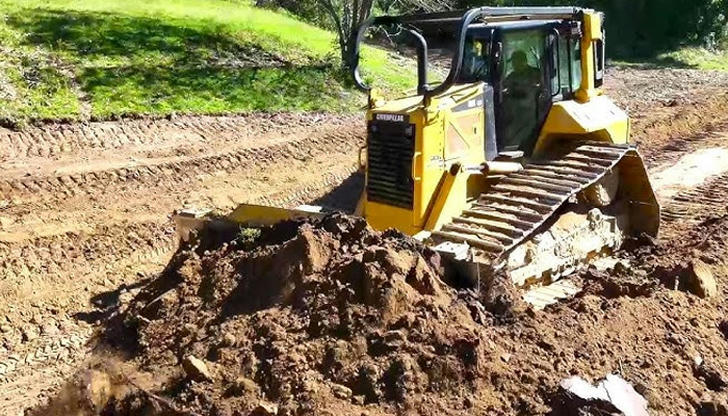 What allows a bulldozer to move over soft or rough terrain?