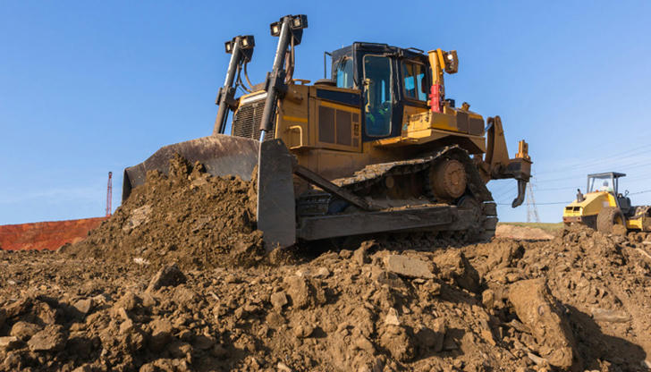 Before turning on a bulldozer, what should be confirmed around it?
