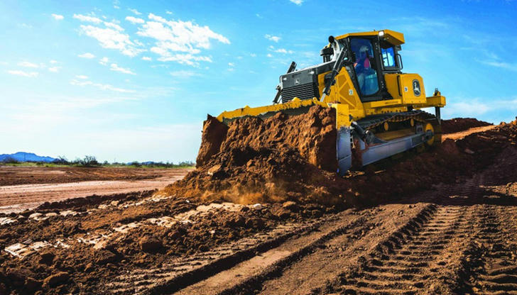 Which machine pushes large amounts of soil across the ground?
