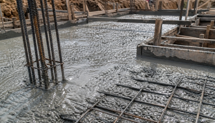 What is the name of the truck fitted with a rotating drum that continuously mixes cement, aggregate, and water during transit to prevent hardening?