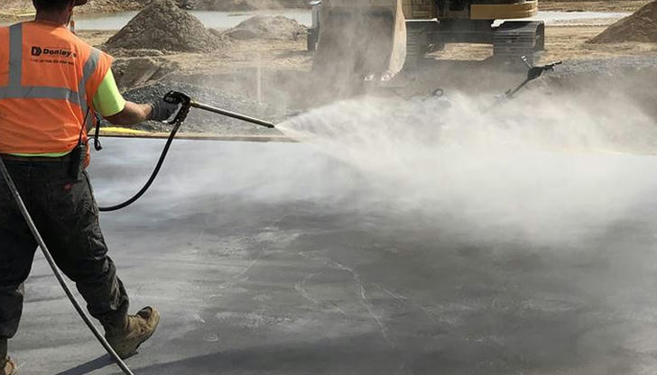 If liquid is sprayed on fresh concrete to slow drying, what is this?