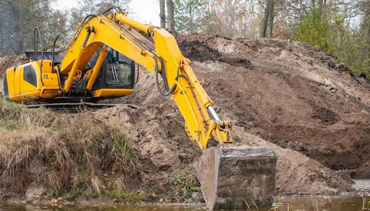 Which machine reaches far or deep with a long arm?