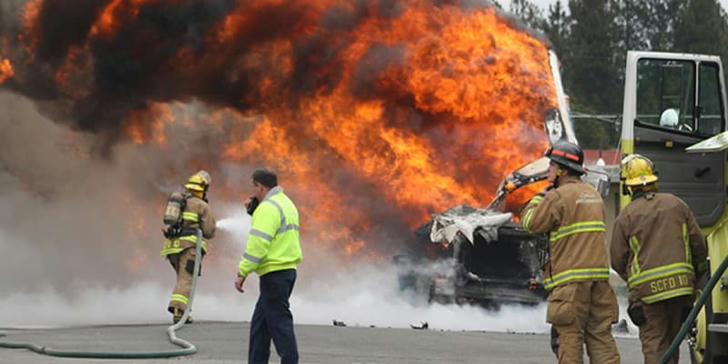 What is the safe distance to stay away from a burning building until firefighters declare it safe?