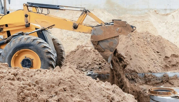 An excavator lowering soil into a trench is performing which task?