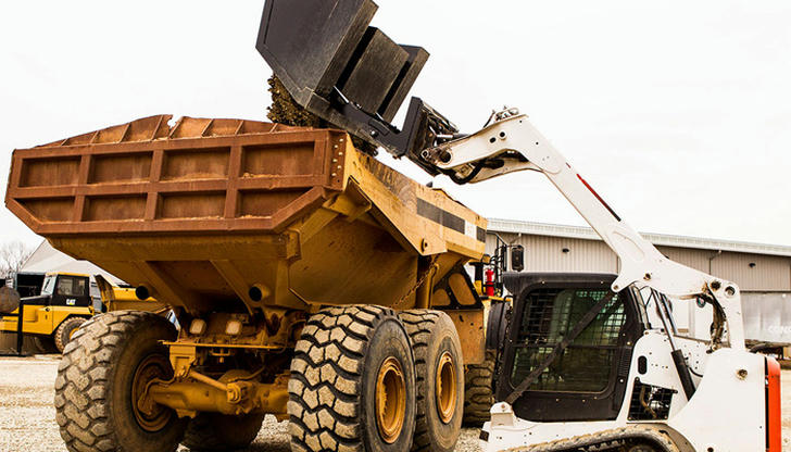 A loader raising its bucket toward a dump truck is in which state?