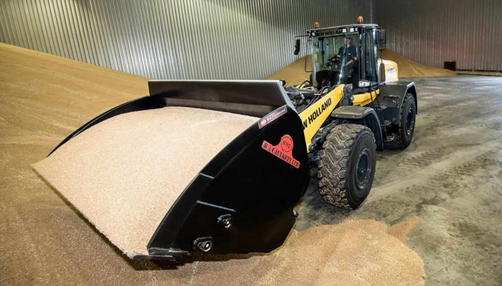 A loader lowering its bucket to empty material is doing what?