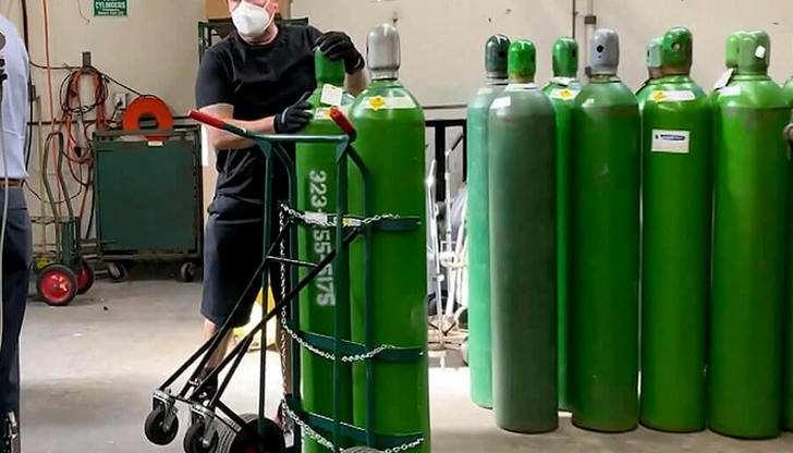 What color typically identifies oxygen tanks in the United States?