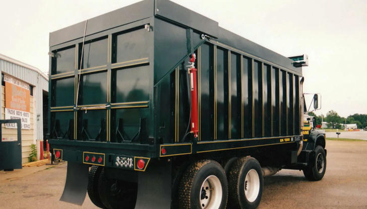 Which part of a dump truck holds soil or sand during transport?