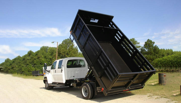 Why is a flatbed truck less suitable for loose materials?