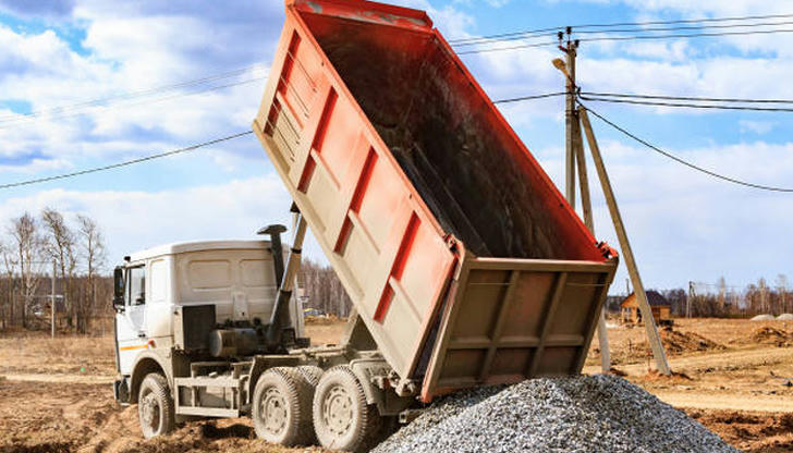 Which road surface often indicates dump trucks are nearby?