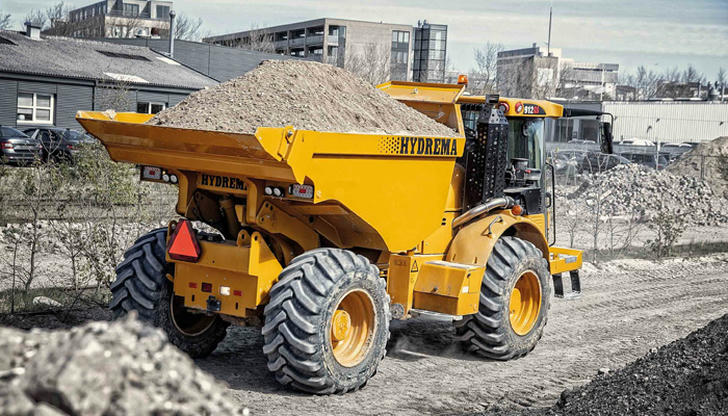 What makes dump trucks harder to stop quickly on job sites?