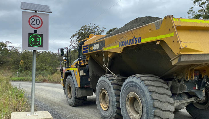 Why do job sites often set lower speed limits near dump trucks?