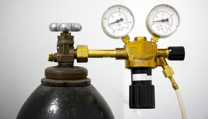 What does a gas regulator control in MIG or TIG welding?