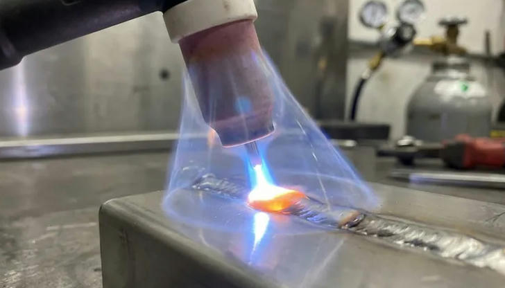 What is the primary role of shielding gas in MIG welding?