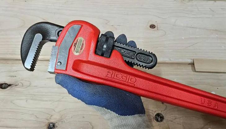 Which tool is used to tighten or loosen pipe connections?