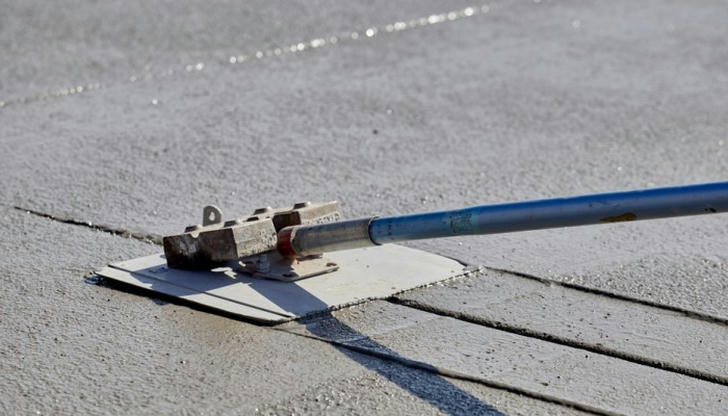 A groover tool is best used during which stage of a concrete pour?