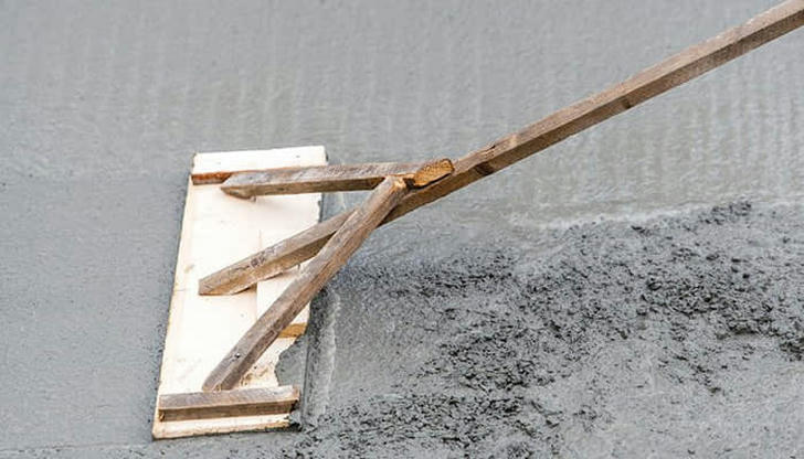 You're leveling a large driveway slab. Which tool is most appropriate immediately after screeding?