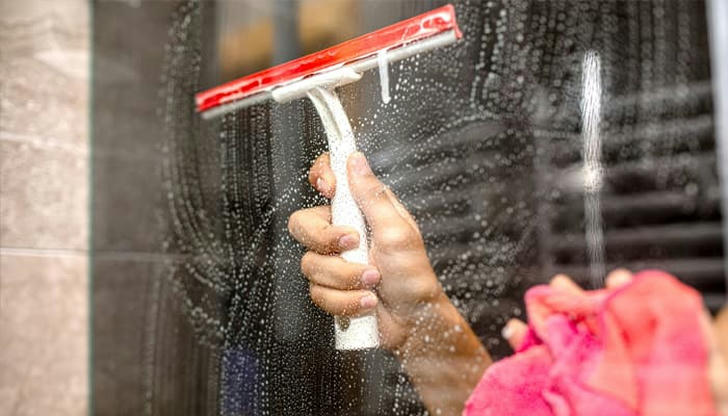 After professional cleaning, how should bathroom glass appear?